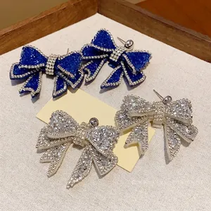 Elegant rhinestone-studded resin bow earrings in luxury blue and sparkling silver
