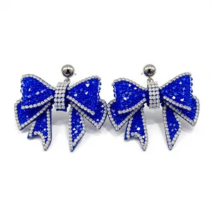 Elegant blue resin bow earrings with sparkling rhinestone edges and silver needle studs