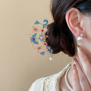 Detailed view of an ornate Chinese style hair stick with enamel flowers and pearls.