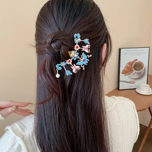 Detailed view of a Chinese style butterfly flower hair pin with a pearl on a hair bun