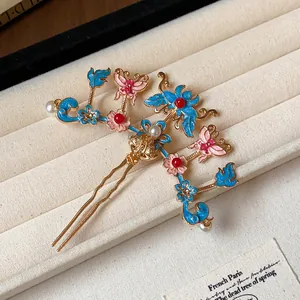 Detail view of a Chinese-style hair fork with enamel butterflies, flowers, and pearls.