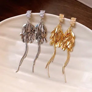 Dettaglio degli orecchini a nappa con zirconi a forma di spiga in oro e argento eleganti