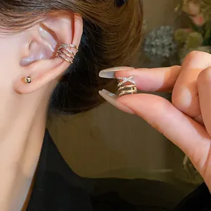 Detailed close-up of a multi-layer rose gold ear cuff featuring pavé zircon X-shaped accents