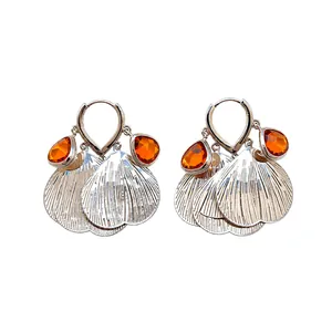 Vintage silver tassel hoop earrings with orange faceted glass petals on white background
