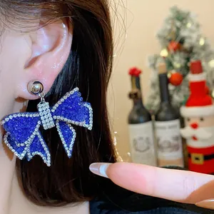 Macro detail view of elegant blue resin bow earring with sparkling rhinestone edges