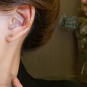 Detailed view of an elegant gold criss-cross multi-layer zircon ear cuff for non-pierced ears.