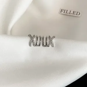 Close-up of elegant silver crisscross multi-layer zircon non-pierced ear cuff on white satin.