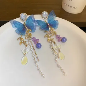 Detailed view of elegant blue gauze butterfly earrings featuring pearl and leaf tassels