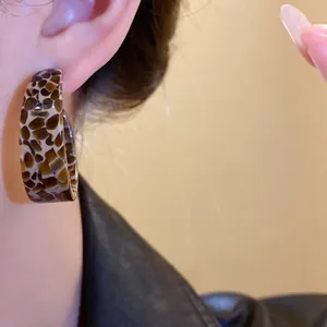 Elegant retro Maillard style acetic acid C-shape earrings worn by an Asian model