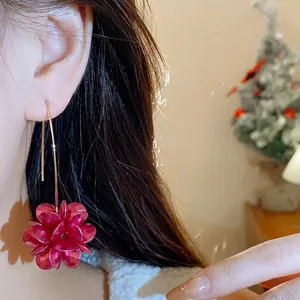 Elegant vintage red flower cluster drop earrings with long gold hooks worn by a model