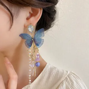 Elegant blue mesh butterfly dangle earrings with pearl tassels worn by an Asian model.