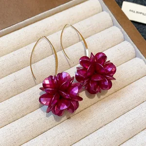 Close-up detail of elegant purple flower drop earrings featuring thin gold hooks.