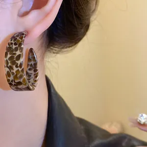 Close-up of a vintage Maillard style C-shaped acetate earring with leopard pattern