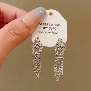 Close-up detail of luxury rhinestone tassel earrings on a 925 silver jewelry display card