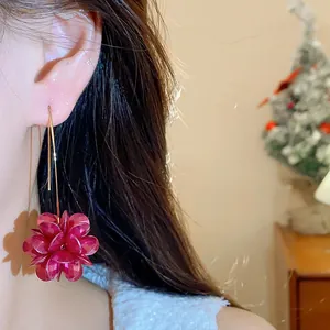 Close-up detail showing a vintage deep red multi-petal flower drop earring with gold hook.