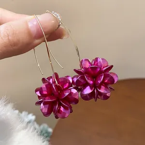 Detailed macro shot of elegant vintage purple metallic flower earrings on gold hooks