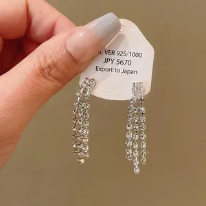 Detailed close-up showing the sparkling silver-toned rhinestone tassel earrings on a tag
