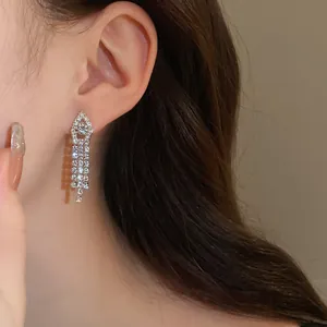 Elegant silver tassel earrings with sparkling rhinestones on model's ear for evening parties