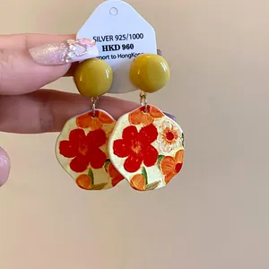 Dettaglio di orecchini floreali irregolari in acrilico con design stile pittura a olio