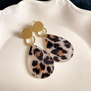 Detailgetreue Nahaufnahme von Retro-Ohrringen mit Leopardenmuster auf weißem Teller