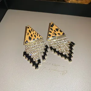 Detailed view of vintage leopard print triangle earrings with shiny rhinestone fringe