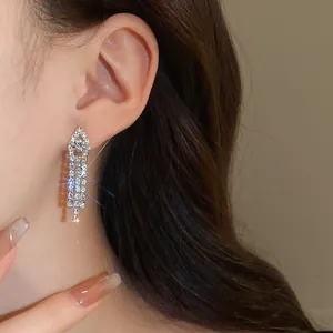 Close-up of elegant silver tassel earrings with sparkling rhinestones for party wear