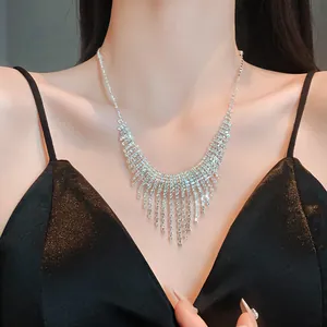 Close-up of sparkling rhinestone tassel necklace worn with a black evening dress