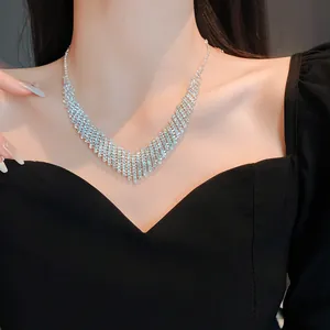 Close-up of a sparkling silver rhinestone fringe necklace on an evening gown model.