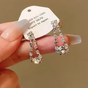 Detailed close-up of elegant silver-toned drop earrings featuring sparkling clear rhinestones.
