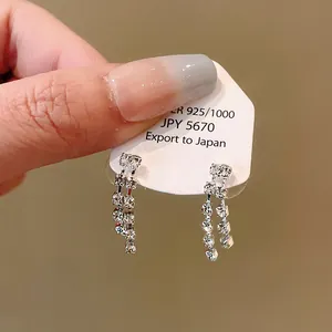 Macro view of elegant rhinestone tassel earrings presented on a 925 silver product tag