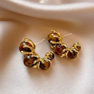 Elegant vintage gold tiger eye C-shaped hoop earrings featuring unique claw settings
