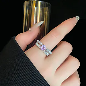 Primo piano di un elegante anello aperto con zircone a cuore rosa e perle sull'indice