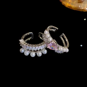 Vista dettagliata di anello vintage con zirconi, perle e cuore rosa con cristalli
