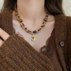 Detail of double-layer necklace with irregular tiger eye stones and teardrop pendant