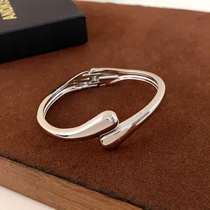 Vue détaillée d'un bracelet jonc argenté minimaliste en forme de goutte pour femme