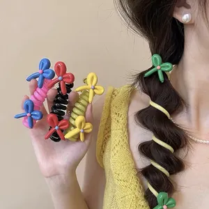 Detail of vibrant colorful spiral hair ties with balloon bow decorations in use on hair