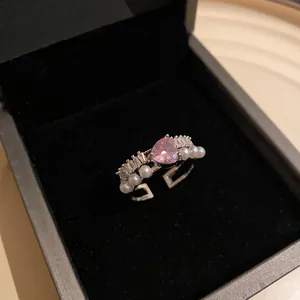 Dettaglio anello con zircone cuore rosa e perle in una scatola regalo nera.