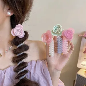 Close-up of pastel rose telephone cord hair ties held in hand and worn on a braid.