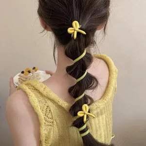 Detailed view of yellow butterfly spiral hair ties on a stylish bubble braid ponytail.
