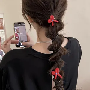 Detailed view of red bow-knot telephone wire hair ties styled in a bubble braid