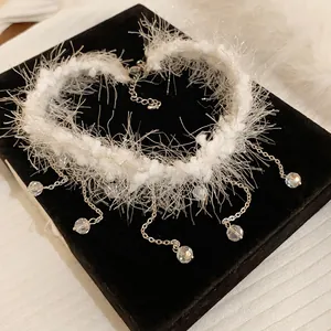 Detailed macro view of white plush choker necklace with sparkling crystal tassels