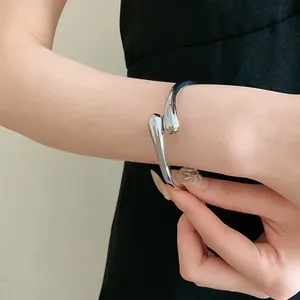 Vue détaillée d'un élégant bracelet jonc argenté en forme de goutte d'eau sur poignet