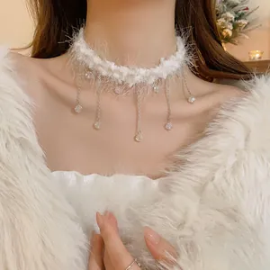 Close-up of white furry choker necklace with delicate crystal tassels and silver chains