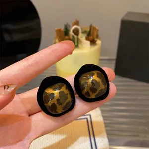Close-up of vintage leopard print resin earrings with elegant velvet-like black borders