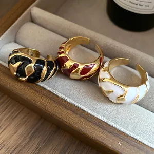 Nahaufnahme von drei Vintage-Emaille-Ringen in Schwarz, Rot und Weiß im Schmuckkästchen.
