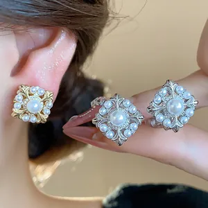 Detail von Vintage-Ohrclips mit Lilienmuster und Perlen in Gold und Silber