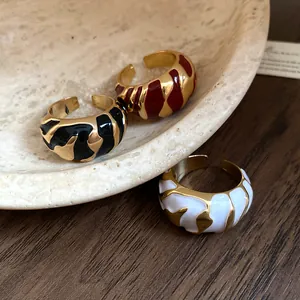Nahaufnahme von vergoldeten Vintage-Ringen mit bunten Emaille-Mustern und offener Form.