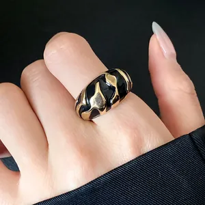 Nahaufnahme eines Vintage-Rings aus Gold und schwarzer Emaille mit Wellenmuster