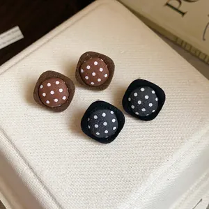 Close-up of vintage fabric polka dot stud earrings with silver needles for autumn