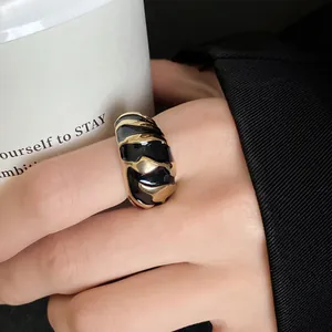 Detailaufnahme eines Vintage-Rings aus Gold und schwarzer Emaille mit Mustern